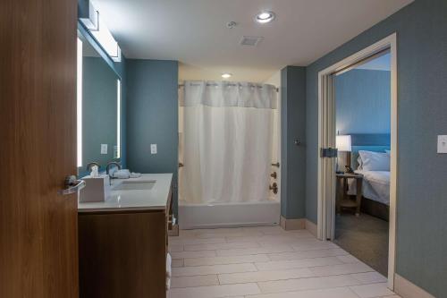 uma casa de banho com um lavatório e um chuveiro com uma cama em Home2 Suites By Hilton Nashville Bellevue em Bellevue