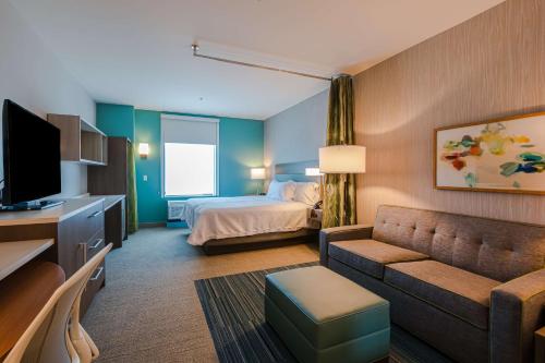 a hotel room with a bed and a couch at Home2 Suites By Hilton Nashville Bellevue in Bellevue