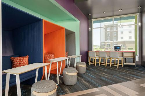 a colorful restaurant with tables and stools in a room at Tru By Hilton Florence I-95 in Florence
