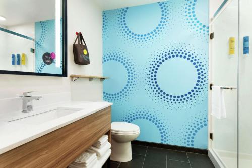 uma casa de banho com um WC e uma parede azul em Tru By Hilton Harbison Columbia em Columbia