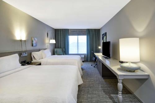 a hotel room with two beds and a television at Hilton Garden Inn Gastonia in Gastonia