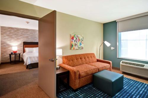Home2 Suites By Hilton Lagrange في لاغرانج: غرفة معيشة مع أريكة وسرير