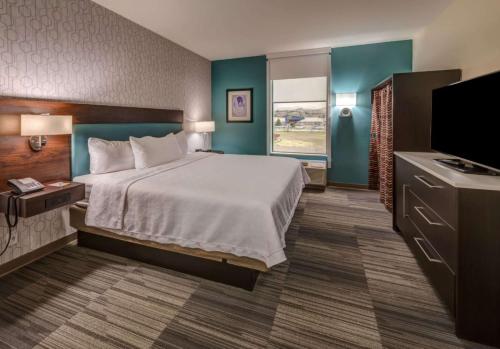 a hotel room with a bed and a flat screen tv at Home2 Suites By Hilton Reno in Reno