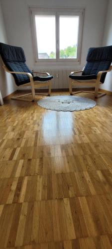 2 sillas y una alfombra en una habitación con suelo de madera en The St.Gallen Feel en St. Gallen