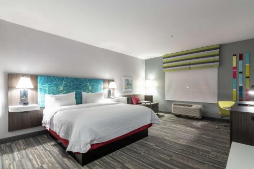 Cette chambre comprend un grand lit et une télévision. dans l'établissement Hampton Inn & Suites Dallas East, à Dallas
