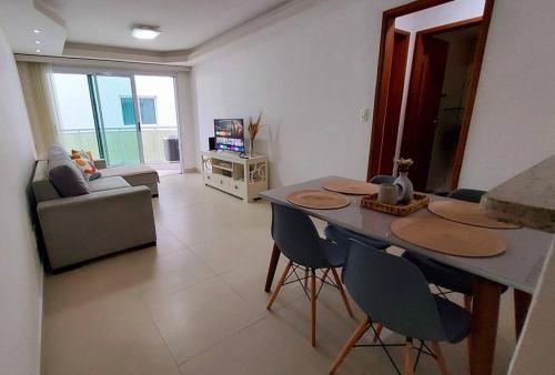 un soggiorno con tavolo, sedie e divano di Apto Centro de Cabo Frio próximo à Praia do Forte! a Cabo Frio