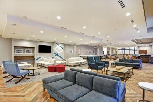 a lobby with couches and chairs and a flat screen tv at Hilton Garden Inn Princeton Lawrenceville in Lawrenceville