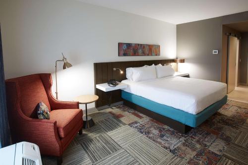 une chambre d'hôtel avec un lit et une chaise dans l'établissement Hilton Garden Inn Elizabethtown, à Elizabethtown