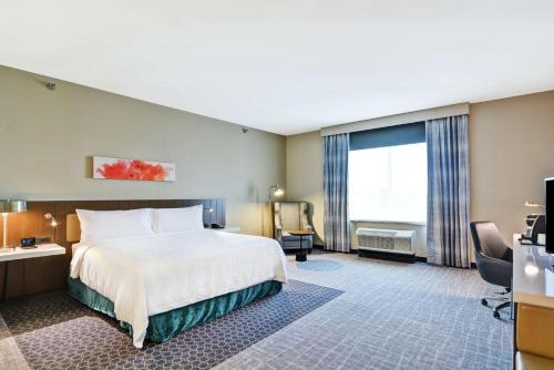 a hotel room with a bed and a large window at Hilton Garden Inn Princeton Lawrenceville in Lawrenceville
