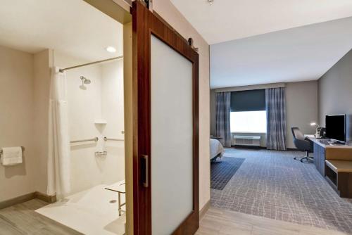 una habitación de hotel con una puerta que conduce a un baño en Hilton Garden Inn Princeton Lawrenceville, en Lawrenceville