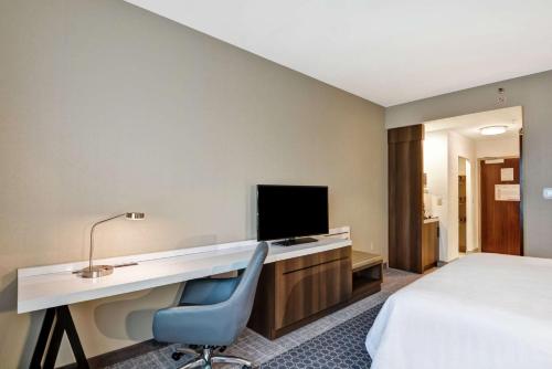 a hotel room with a desk and a bed at Hilton Garden Inn Princeton Lawrenceville in Lawrenceville