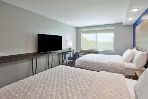 a hotel room with two beds and a flat screen tv at Tru By Hilton Jackson in Jackson