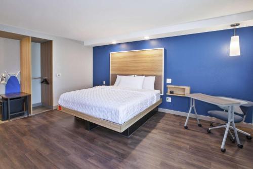a bedroom with a bed and a desk and a bed sidx sidx sidx at Tru By Hilton Jackson in Jackson