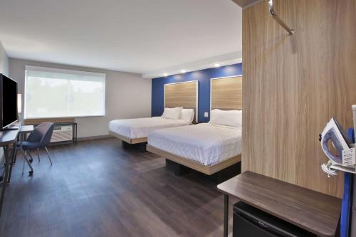 a hotel room with two beds and a desk and a tv at Tru By Hilton Jackson in Jackson