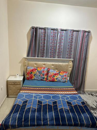 a bed with a headboard and pillows in a room at Fateh Building in Dubai