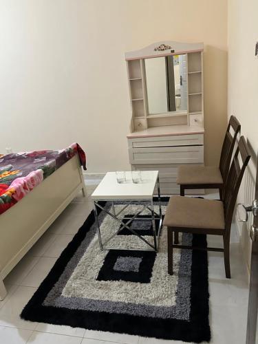 a bedroom with a bed and a table and a mirror at Fateh Building in Dubai