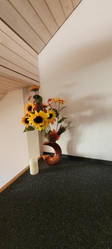 Una habitación con un jarrón con flores. en The St.Gallen Feel en St. Gallen