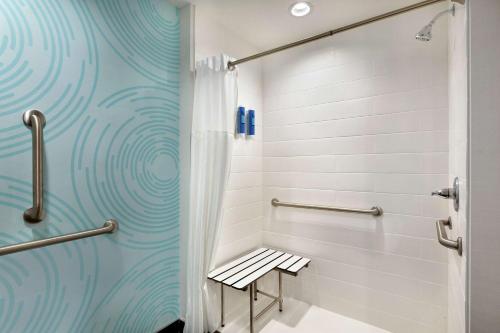 a shower stall with a bench in a bathroom at Tru by Hilton Webster Houston NASA in Webster