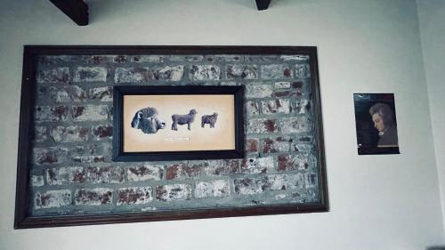 a framed picture of horses on a brick wall at Exquisito departamento “Boutique” in Balcarce