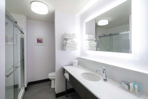 a bathroom with a sink and a toilet and a mirror at Hampton Inn Weston, WV in Weston