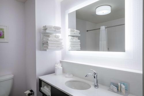 een witte badkamer met een wastafel en een spiegel bij Hampton Inn Weston, WV in Weston