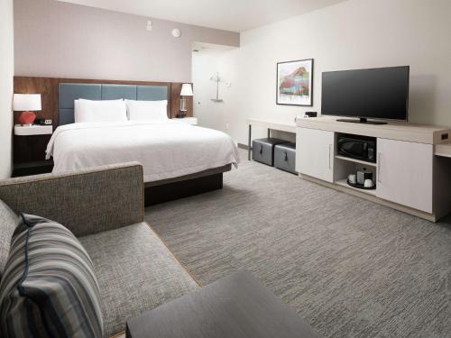 a hotel room with a bed and a flat screen tv at Hampton Inn Chattanooga East Ridge in Chattanooga