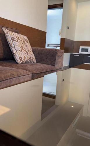 a couch with a pillow on it in a room at Tamrah Suites Hotel in Amman