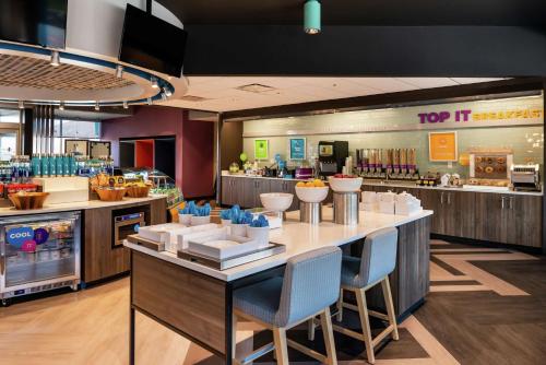 a restaurant with a large counter with chairs and a food court at Tru By Hilton Staunton in Staunton