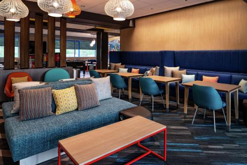 a restaurant with a couch and tables and chairs at Tru By Hilton Staunton in Staunton