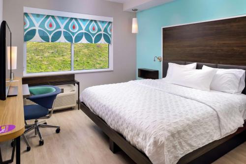 a bedroom with a bed and a desk and a window at Tru By Hilton Staunton in Staunton