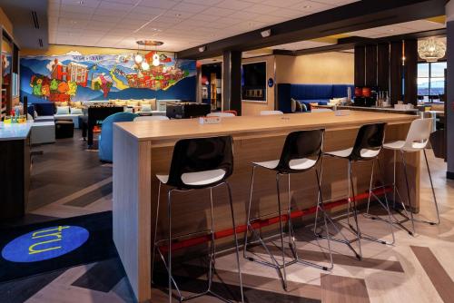 a bar in a restaurant with stools around it at Tru By Hilton Staunton in Staunton