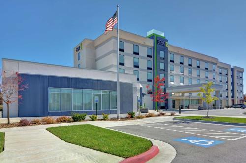 an office building with an american flag in front of it at Home2 Suites By Hilton Springdale in Springdale
