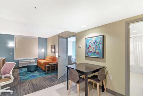 a living room with a table and chairs and a couch at Home2 Suites By Hilton Clarksville Louisville North in Clarksville