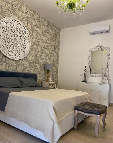 una camera con un grande letto e uno specchio di B&B a Pompei Gaudium da 1 a 5 posti letto a Scafati