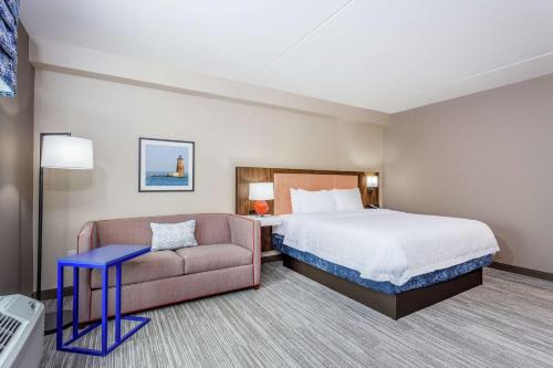 a hotel room with a bed and a couch at Hampton Inn & Suites Kittery-Portsmouth in Kittery
