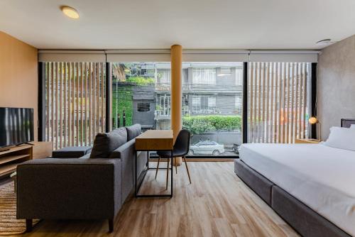 a bedroom with a bed and a couch and a desk at Condesa Cholula Lofts by VH in Mexico City