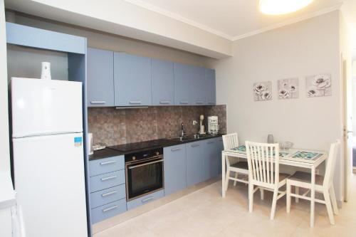 uma cozinha com armários azuis e uma mesa com cadeiras em Desire place em Lefkada