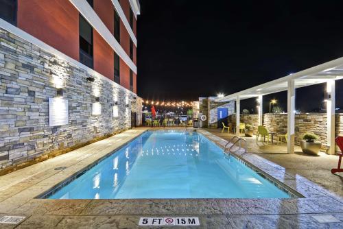 a swimming pool in front of a building at night at Home2 Suites By Hilton Warner Robins in Warner Robins
