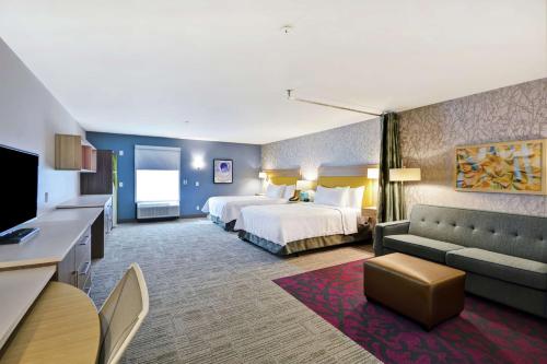 une chambre d'hôtel avec un lit et un canapé dans l'établissement Home2 Suites By Hilton Warner Robins, à Warner Robins
