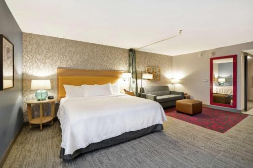 a hotel room with a large bed and a couch at Home2 Suites By Hilton Warner Robins in Warner Robins