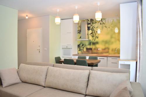 Il comprend un salon avec un canapé et une cuisine. dans l'établissement Olive Tree Apartment - 290, à Mullini i Danit