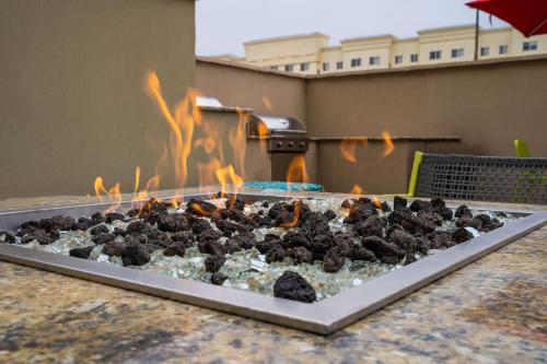 a fire pit with a bunch of black rocks at Home2 Suites By Hilton San Antonio At The Rim, Tx in San Antonio