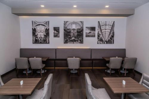 a restaurant with wooden tables and chairs and pictures on the wall at Hampton Inn & Suites By Hilton Puebla in Puebla