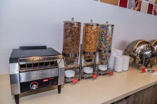 a kitchen counter with four tall containers of food at Hampton Inn & Suites By Hilton Puebla in Puebla