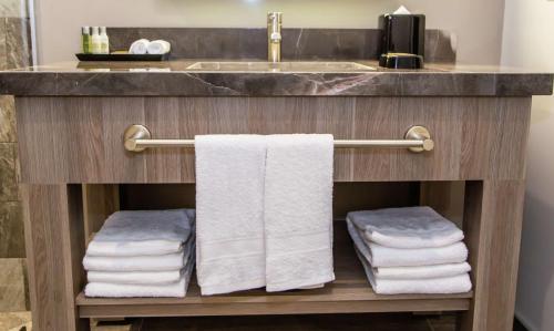a bathroom with a sink and a bunch of towels at Hampton Inn & Suites By Hilton Puebla in Puebla