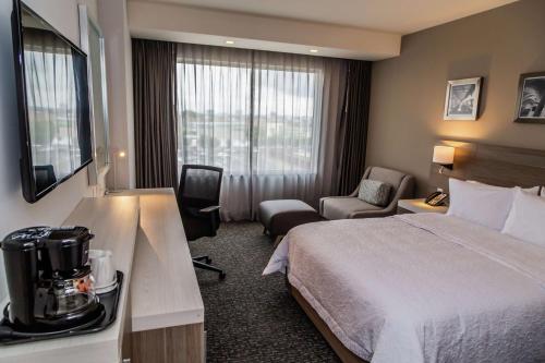 Pokój hotelowy z łóżkiem i krzesłem w obiekcie Hampton Inn & Suites By Hilton Puebla w mieście Puebla