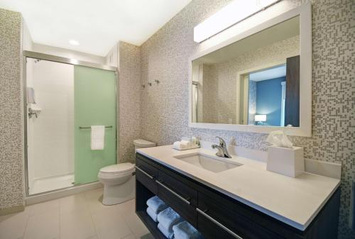 een badkamer met een wastafel, een toilet en een spiegel bij Home2 Suites By Hilton Beloit in Beloit