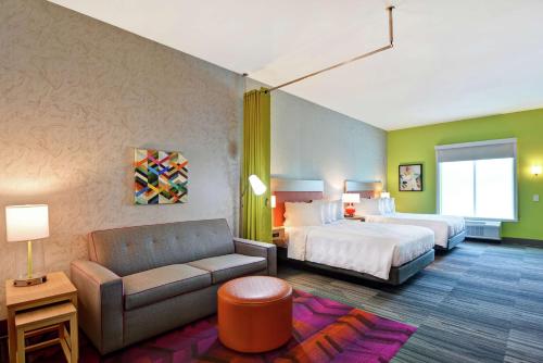 um quarto de hotel com uma cama e um sofá em Home2 Suites Charleston West Ashley em Charleston