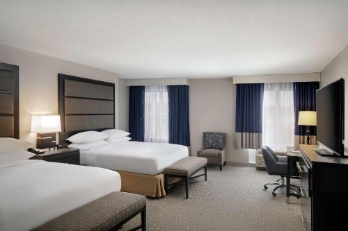 a hotel room with two beds and a desk at DoubleTree Richmond Airport in Sandston