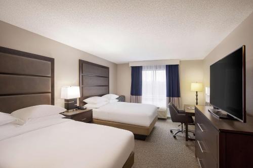 a hotel room with two beds and a flat screen tv at DoubleTree Richmond Airport in Sandston
